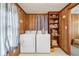 A functional laundry room boasting wooden paneling, shelving, a window and modern washer and dryer units at 645 Camp Perrin Rd, Lawrenceville, GA 30043
