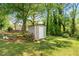 Outdoor shed for extra storage in a beautifully landscaped yard with green trees at 645 Camp Perrin Rd, Lawrenceville, GA 30043
