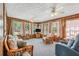 Bright sunroom with wood-paneled walls, multiple windows, and comfortable seating arrangements at 645 Camp Perrin Rd, Lawrenceville, GA 30043