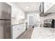 A modern kitchen featuring granite counters, stainless appliances, and gray tile flooring at 725 Dalrymple Rd # 3G, Atlanta, GA 30328