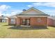 Brick home featuring a well-maintained lawn and covered back patio at 8495 Spivey Village Way, Jonesboro, GA 30236