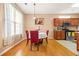 Dining area with hardwood floors, red chairs around a table, and natural light from the window at 8495 Spivey Village Way, Jonesboro, GA 30236
