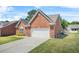 Brick home featuring a two-car garage and concrete driveway, surrounded by a green lawn at 8495 Spivey Village Way, Jonesboro, GA 30236