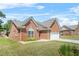 Charming brick home featuring an arched window, two-car garage, and well-maintained lawn at 8495 Spivey Village Way, Jonesboro, GA 30236