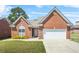 Charming brick home with well-manicured lawn, arched window, and attached two-car garage at 8495 Spivey Village Way, Jonesboro, GA 30236