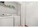 Efficient laundry area with a side-by-side washer and dryer, storage shelf, and an entry door at 8495 Spivey Village Way, Jonesboro, GA 30236