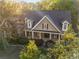 Aerial view of a two-story home with a covered front porch and professionally landscaped yard at 6050 Providence Ln, Cumming, GA 30040