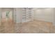 Bright basement area with tile floors, white shelving, and an open doorway to a hallway at 6050 Providence Ln, Cumming, GA 30040