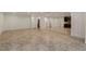Open basement area with tile flooring, white trim, recessed lighting, and a wet bar in the background at 6050 Providence Ln, Cumming, GA 30040