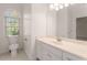 Bright bathroom with a large mirror, white cabinets, and a window providing natural light at 6050 Providence Ln, Cumming, GA 30040