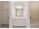 Bathroom with a vanity with white cabinets, a mirror, a tub, and a walk-in closet at 6050 Providence Ln, Cumming, GA 30040