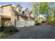 Three-car garage with white doors, side entry door, and large paved driveway at 6050 Providence Ln, Cumming, GA 30040
