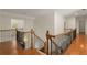 Hallway features hardwood flooring, wrought iron railings, wood banisters, and crown molding at 6050 Providence Ln, Cumming, GA 30040