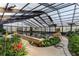 Beautiful indoor pool with lush plants and ample lighting from expansive glass ceilings at 6050 Providence Ln, Cumming, GA 30040
