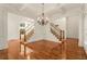 Open living space with hardwood floors, staircase, wainscoting, and natural light at 6050 Providence Ln, Cumming, GA 30040