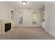 Cozy living room with a fireplace, built-in bookshelves, and large windows providing natural light at 6050 Providence Ln, Cumming, GA 30040