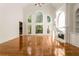 Bright living room featuring large windows, a fireplace, and gleaming hardwood floors at 6050 Providence Ln, Cumming, GA 30040