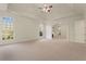 Large main bedroom features tray ceiling, ceiling fan, large windows, and doorway to another room at 6050 Providence Ln, Cumming, GA 30040