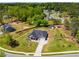 An aerial view of a home with a long driveway and well-manicured lawn in a suburban neighborhood at 7001 Palomino Trl, Winston, GA 30187