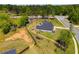 An aerial view of the house with a large, partially fenced yard with grass and a long driveway at 7001 Palomino Trl, Winston, GA 30187
