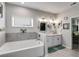Elegant bathroom with soaking tub, dual vanities, modern fixtures, and views into the main bedroom at 7001 Palomino Trl, Winston, GA 30187