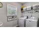 This clean laundry room has a washer, dryer, a window, and a cute sign at 7001 Palomino Trl, Winston, GA 30187