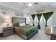 Elegant main bedroom with tufted headboard, accent pillows, sitting chair, and decorative floral arrangements at 7001 Palomino Trl, Winston, GA 30187