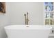 Soaking tub in a luxurious bathroom with a modern faucet and serene view at 11815 Mountain Laurel Dr, Roswell, GA 30075
