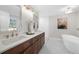 Elegant bathroom featuring a double vanity, soaking tub, and modern fixtures at 11815 Mountain Laurel Dr, Roswell, GA 30075