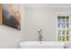 Soaking tub in a luxurious bathroom with a modern faucet and serene view at 11815 Mountain Laurel Dr, Roswell, GA 30075