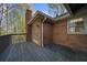 A wooden deck featuring a brick exterior with access door and chimney at 11815 Mountain Laurel Dr, Roswell, GA 30075