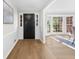 Bright entry foyer with hardwood flooring, wainscoting, and a black front door at 11815 Mountain Laurel Dr, Roswell, GA 30075