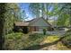 Rear exterior view of home with brick siding, an attached garage and a lush, green yard at 11815 Mountain Laurel Dr, Roswell, GA 30075