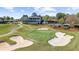 A picturesque aerial view of the golf course, bunkers, and clubhouse at 11815 Mountain Laurel Dr, Roswell, GA 30075