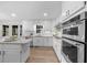 Kitchen featuring stainless steel appliances, marble countertops, and modern white cabinetry at 11815 Mountain Laurel Dr, Roswell, GA 30075