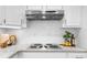 Bright kitchen with stainless steel range hood, white cabinetry, and granite countertops at 11815 Mountain Laurel Dr, Roswell, GA 30075