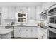 Kitchen with stainless steel appliances, white cabinetry, and updated countertops at 11815 Mountain Laurel Dr, Roswell, GA 30075