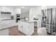 Open kitchen featuring an island, stainless steel appliances, and light wood floors at 11815 Mountain Laurel Dr, Roswell, GA 30075