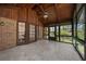 An enclosed sunroom with brick accents, tile floors, wood ceiling, and screened windows overlooking the lush landscape at 11815 Mountain Laurel Dr, Roswell, GA 30075