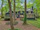 Exterior back of home view from the wooded backyard showcasing a deck, large windows, and privacy at 3988 Dover Ave, Alpharetta, GA 30009