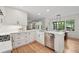 Bright white kitchen featuring stainless steel appliances, and wood flooring, adjacent to the dining area at 3988 Dover Ave, Alpharetta, GA 30009