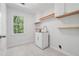 Well-lit laundry room with upper cabinets, a sink, and patterned tile flooring at 3988 Dover Ave, Alpharetta, GA 30009