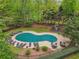 An aerial view of a kidney-shaped pool, covered for the off-season, surrounded by chairs and tables at 3988 Dover Ave, Alpharetta, GA 30009