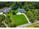 Aerial view of property with expansive lawn and circular driveway, with a neighboring in-ground pool at 4149 Yancey Rd, Douglasville, GA 30135