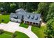 Aerial view of a well-maintained home with a large driveway, manicured lawn, and mature trees at 4149 Yancey Rd, Douglasville, GA 30135