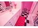 Unique bathroom with pink walls, black and white checkered floor, and zebra-striped accents at 4149 Yancey Rd, Douglasville, GA 30135