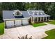 Home with a three car garage and a charming front porch with decorative columns and manicured lawn at 4149 Yancey Rd, Douglasville, GA 30135