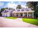 Beautifully landscaped home boasting a large front porch with rocking chairs and a three-car garage at 4149 Yancey Rd, Douglasville, GA 30135