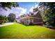 Classic home boasts a charming front porch with rocking chairs, spacious yard, and long circular driveway at 4149 Yancey Rd, Douglasville, GA 30135