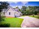 Home features a three-car garage, expansive driveway, and manicured lawn with decorative flower bed at 4149 Yancey Rd, Douglasville, GA 30135